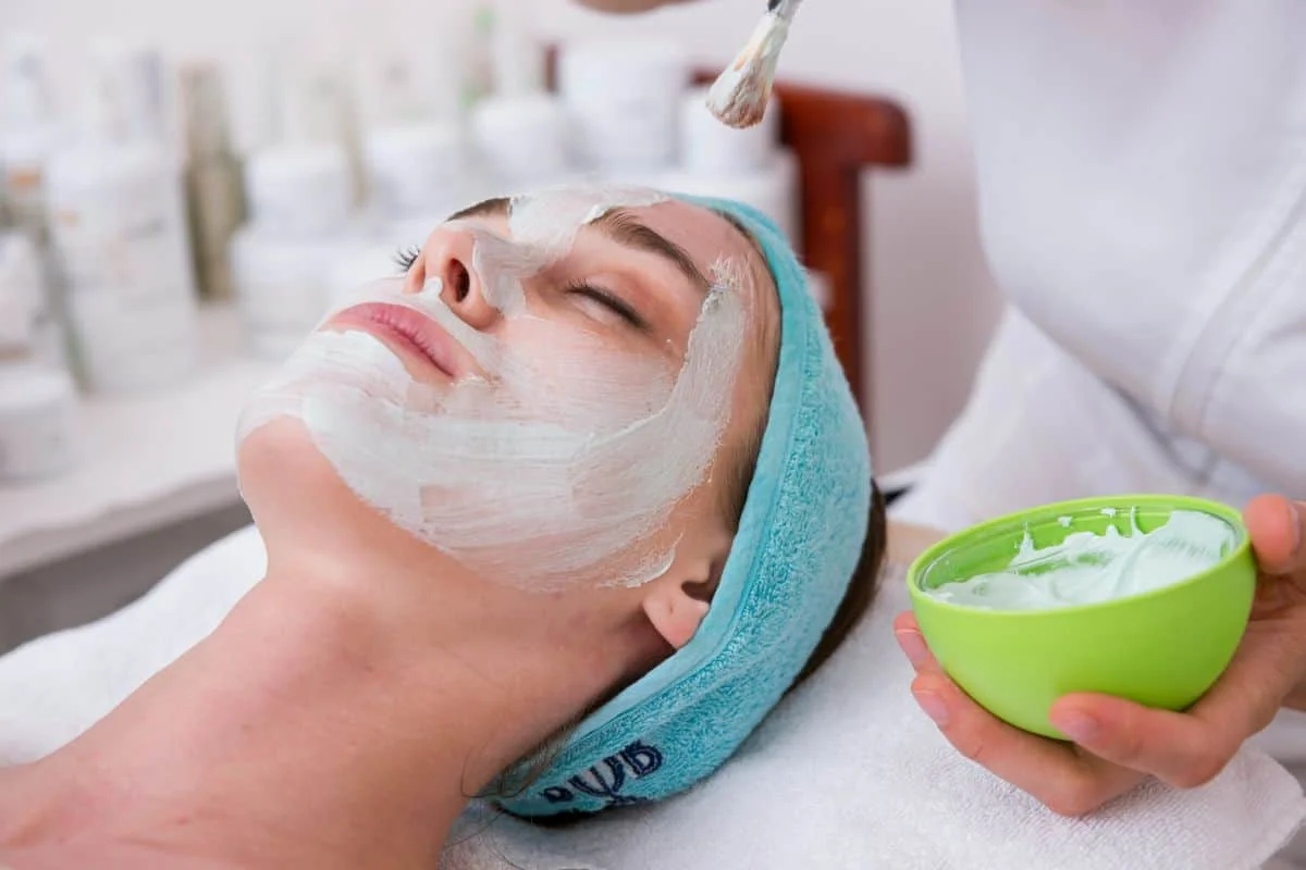 Skin Care Services in Tampa, FL 1 A woman undergoing a facial skin care treatment in a tranquil spa setting, emphasizing self-care and skincare wellness